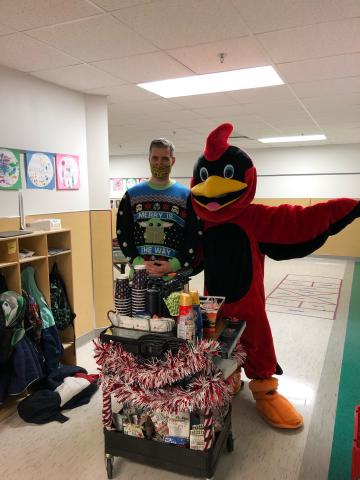 Abingdon Cardinal posing with the principal. The Cardinal is handing out coffee to teachers.