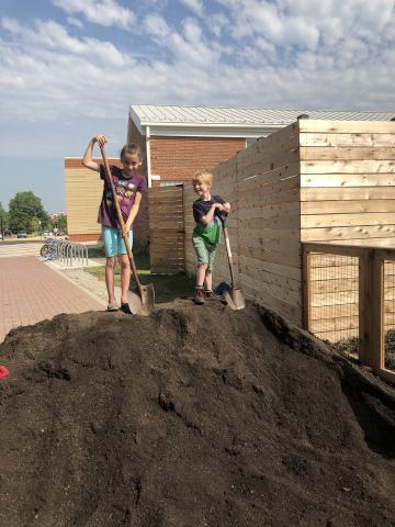 Volunteers posing on top of a pile of mulch in the Abingdon Garden