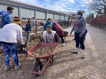 Volunteers carrying woodchips into the garden